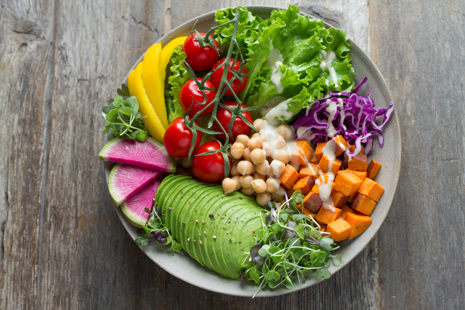 Piatto con verdure fresche, avocado e legumi